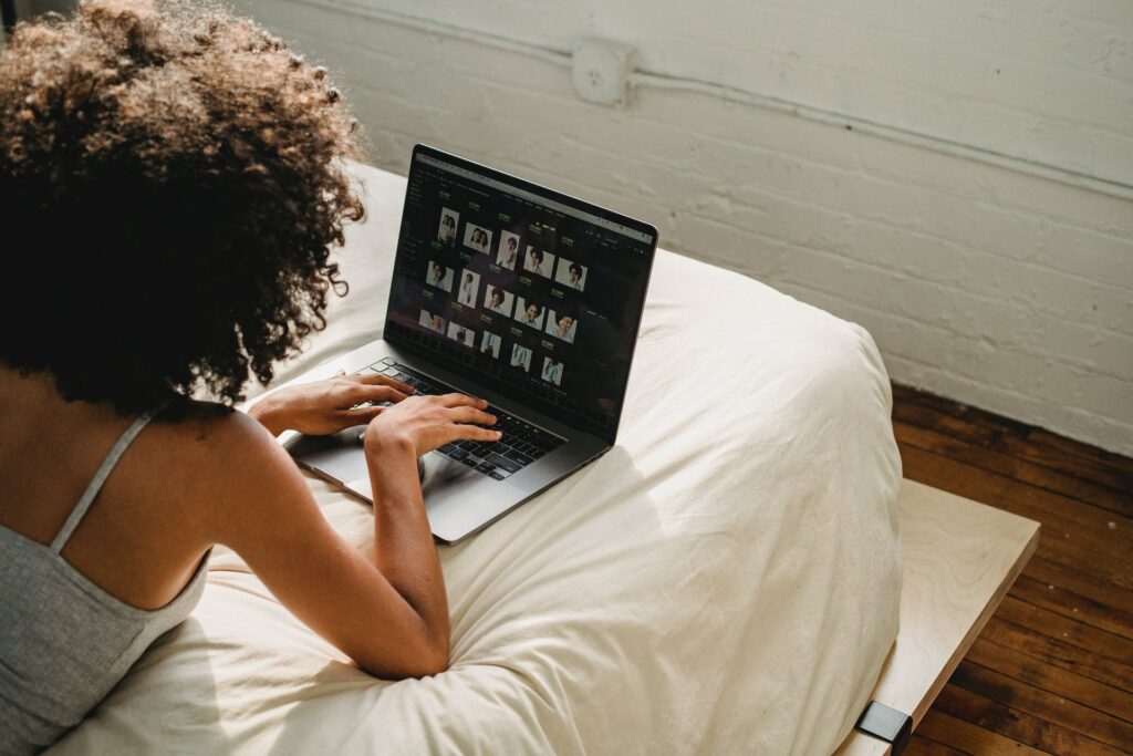 Woman using laptop on her bed